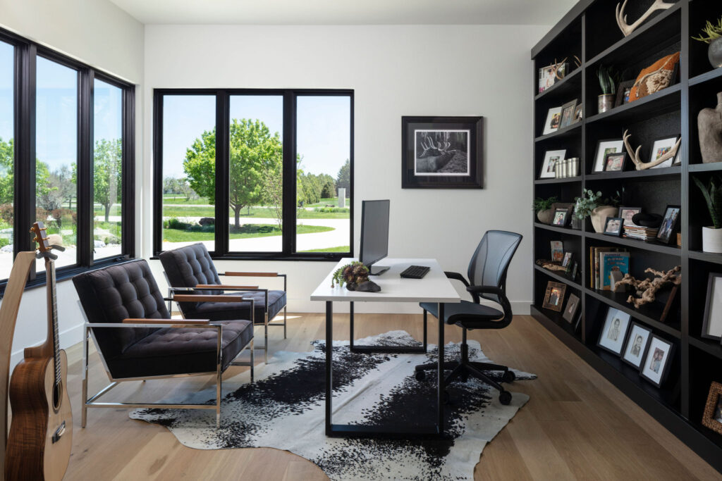 Wildflower custom home - home office with family photos/mementos displayed on custom shelves and view of front yard out the windows