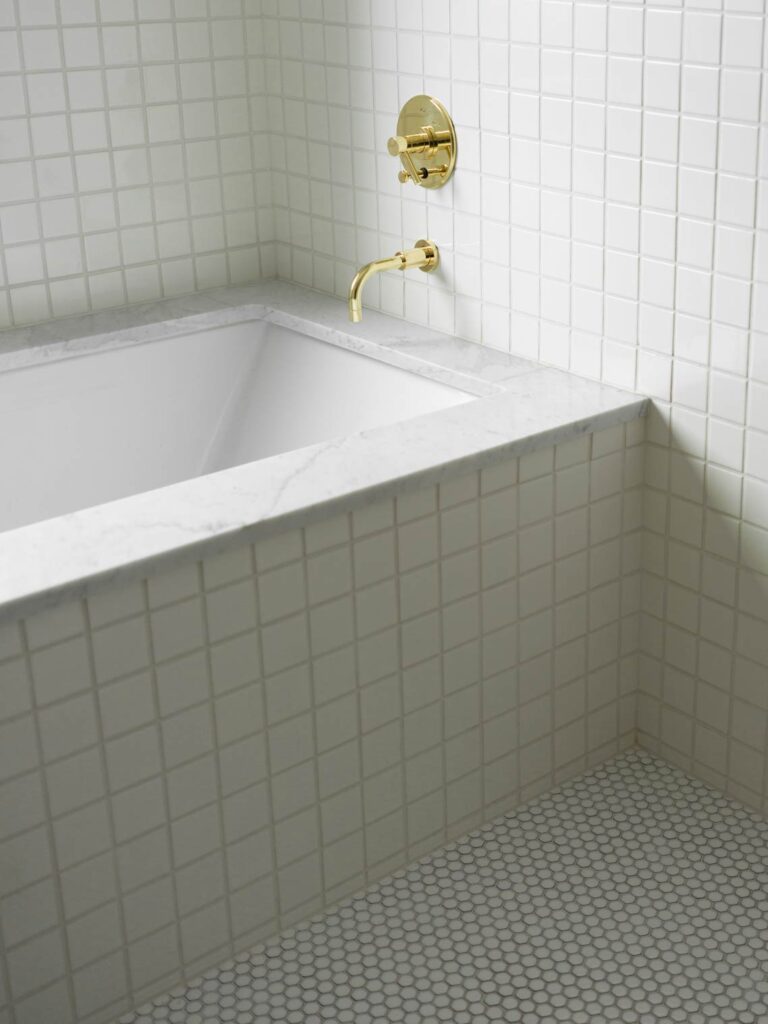 white tile and gold fixtures tub
