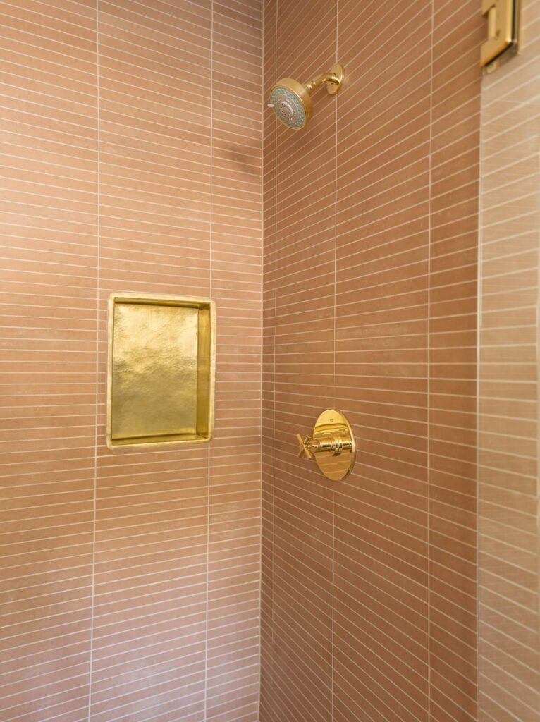 pink tile and gold fixtures shower