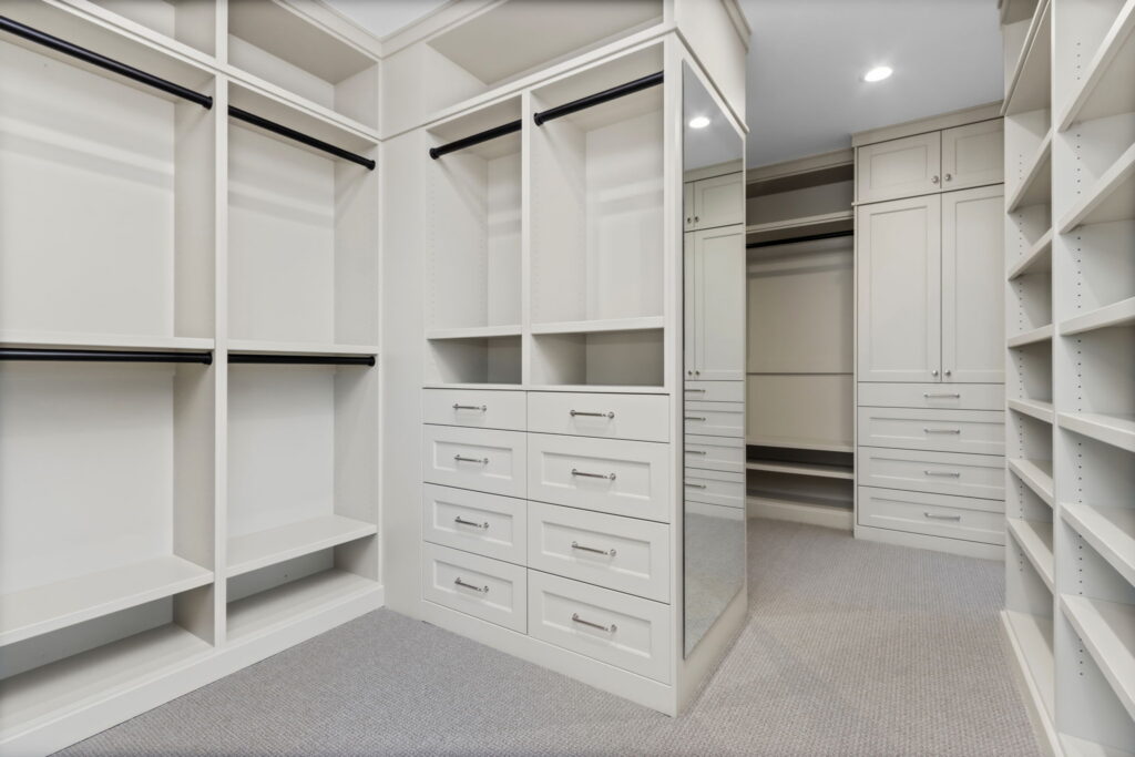 walk in closet with white finishings